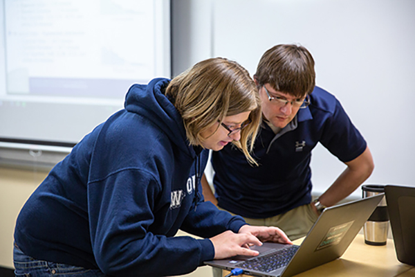 Student Erica Kelly goes over a problem with Assistant Professor Tyler Skorczewski in the Industrial Math class.