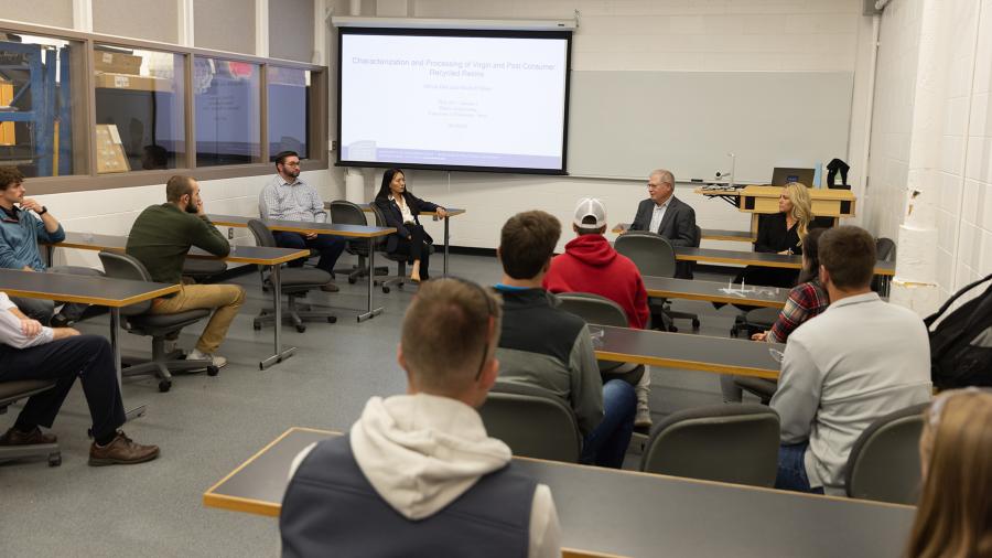 EVCO's Dale Evans and Anna Bartz, front right, talk with plastics engineering students in a classroom.
