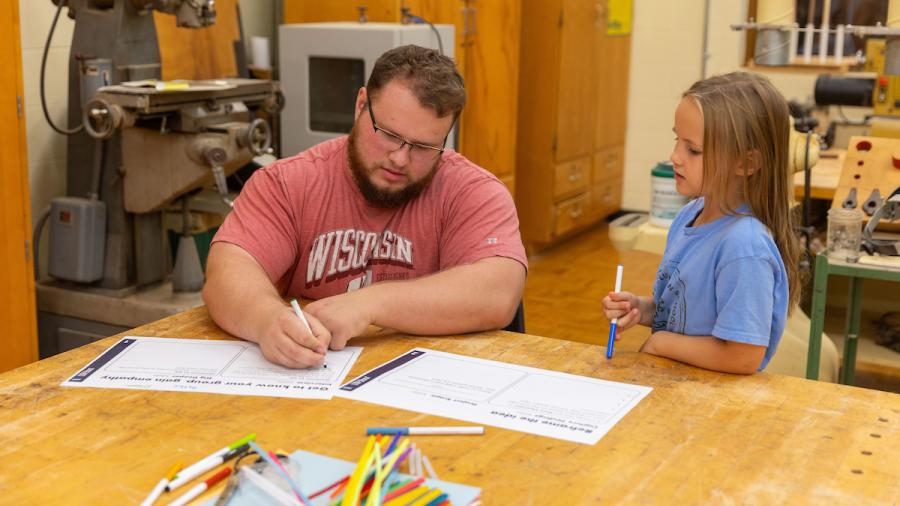 Packaging student Isaiah Rolli designs a toy doghouse with a first-grade student.