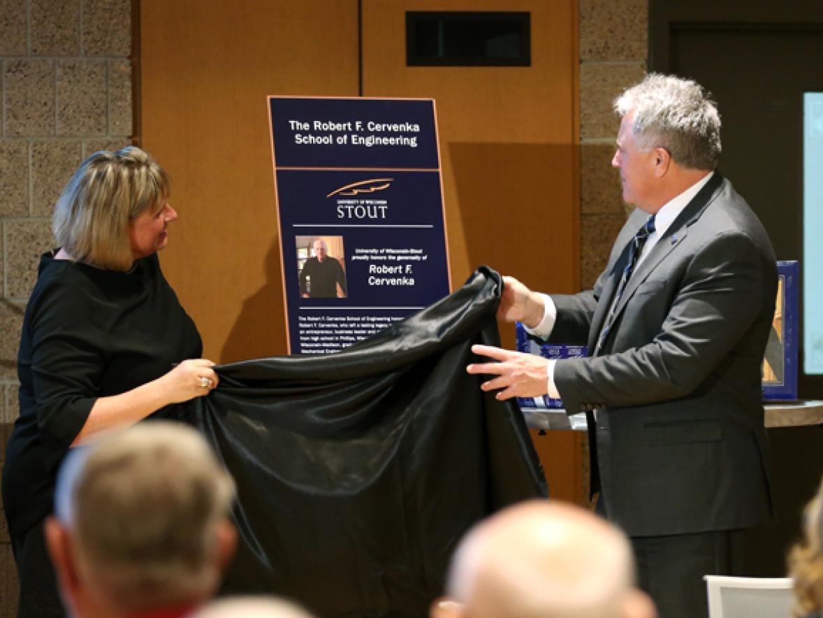 A friend of the Cervenka family, Leslie Lagerstrom, left, unveils a plaque with Chancellor Bob Meyer for the Robert F. Cervenka School of Engineering at a dedication ceremony Friday, Oct. 27, at UW-Stout.