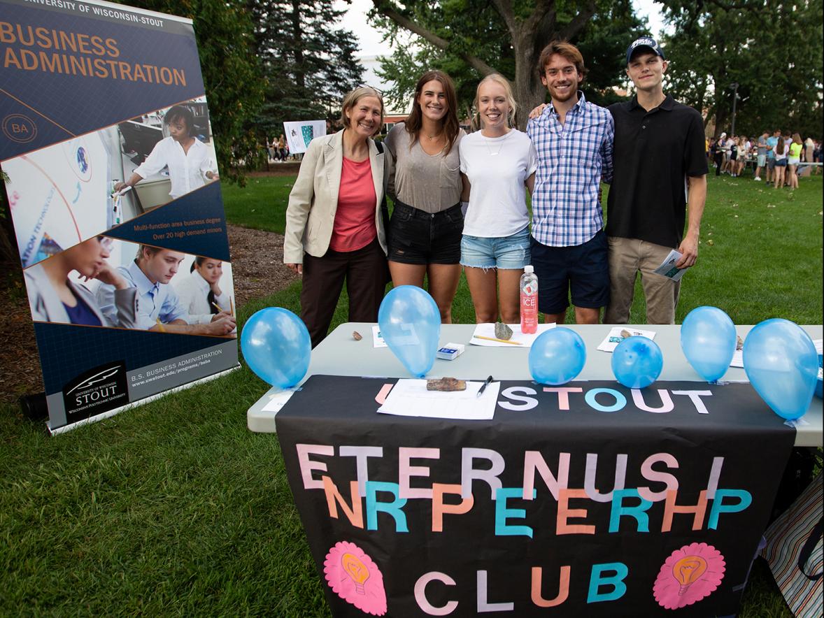 From left, Assistant Professor Mary Spaeth, Megan Nimsgern, Kayla Bolster and other members of the Entrepreneurship Club gather at the Backyard Bash student event on campus in September.