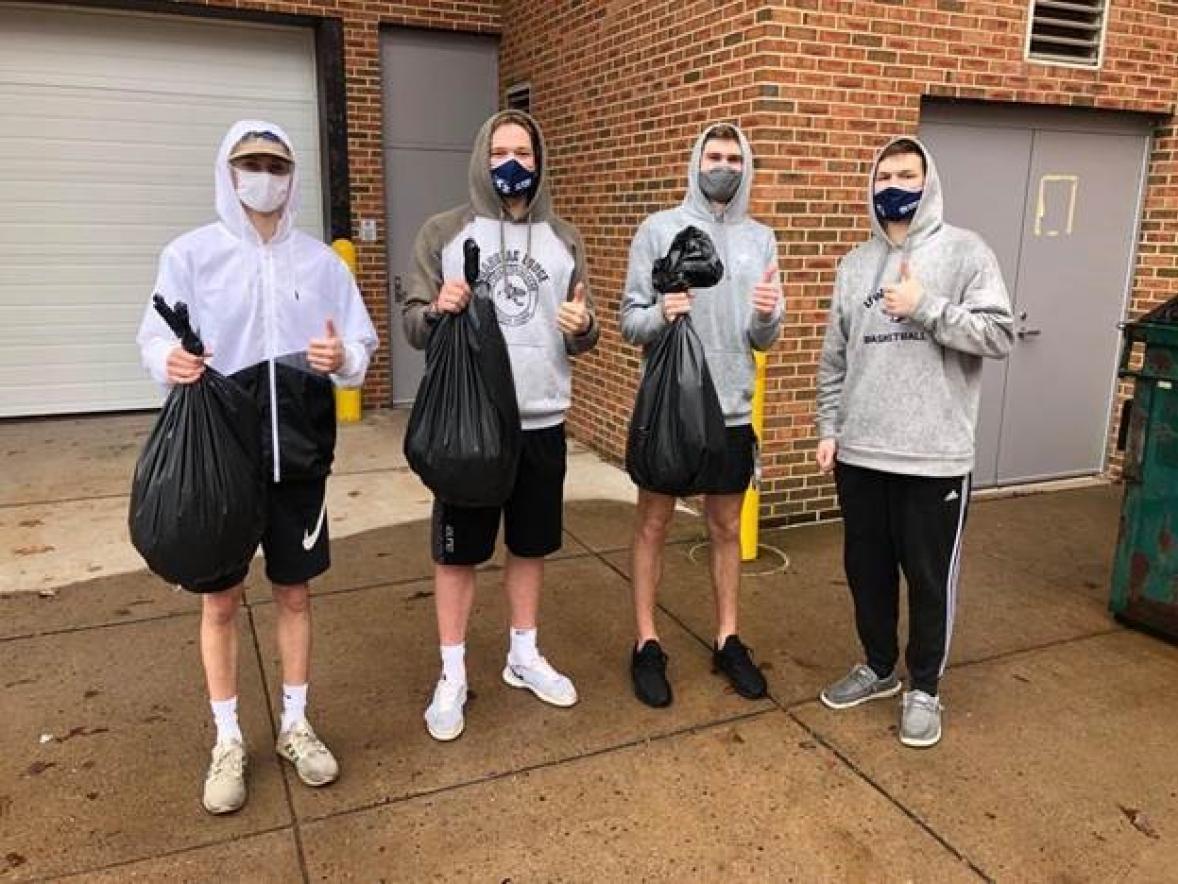 Students collecting trash on campus.