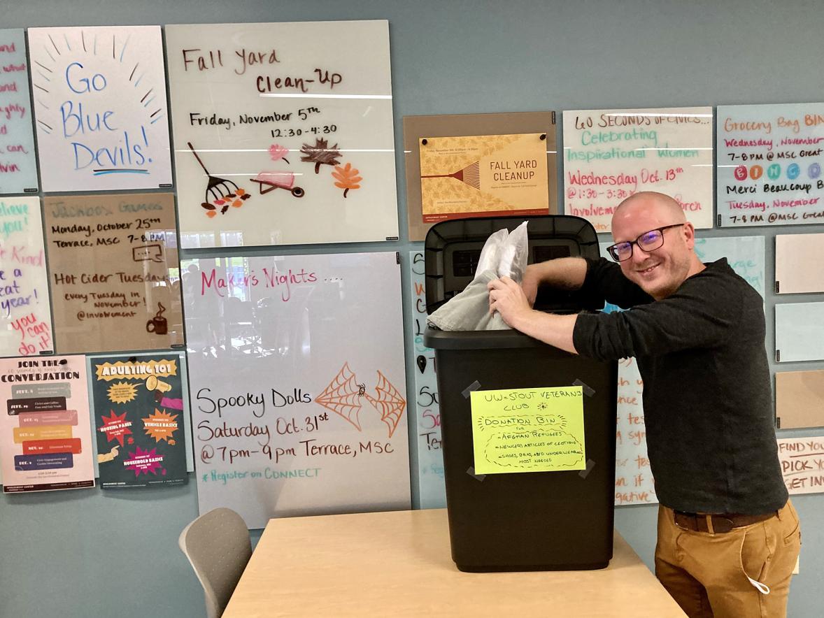 Veterans Club President Eric Gritzmacher collects items donated to help Afghan evacuees at one of two bins in the UW-Stout Memorial Student Center. The university Veterans Club is sponsoring the drive to collect new or like-new clothing until Monday, Nov. 8.