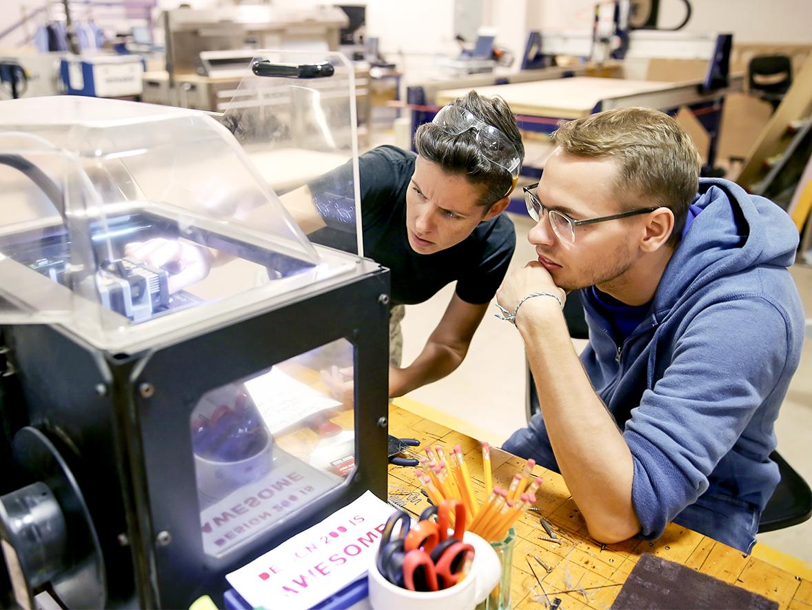 Faculty and students work with a 3D printer in the Fab Lab, UW-Stout
